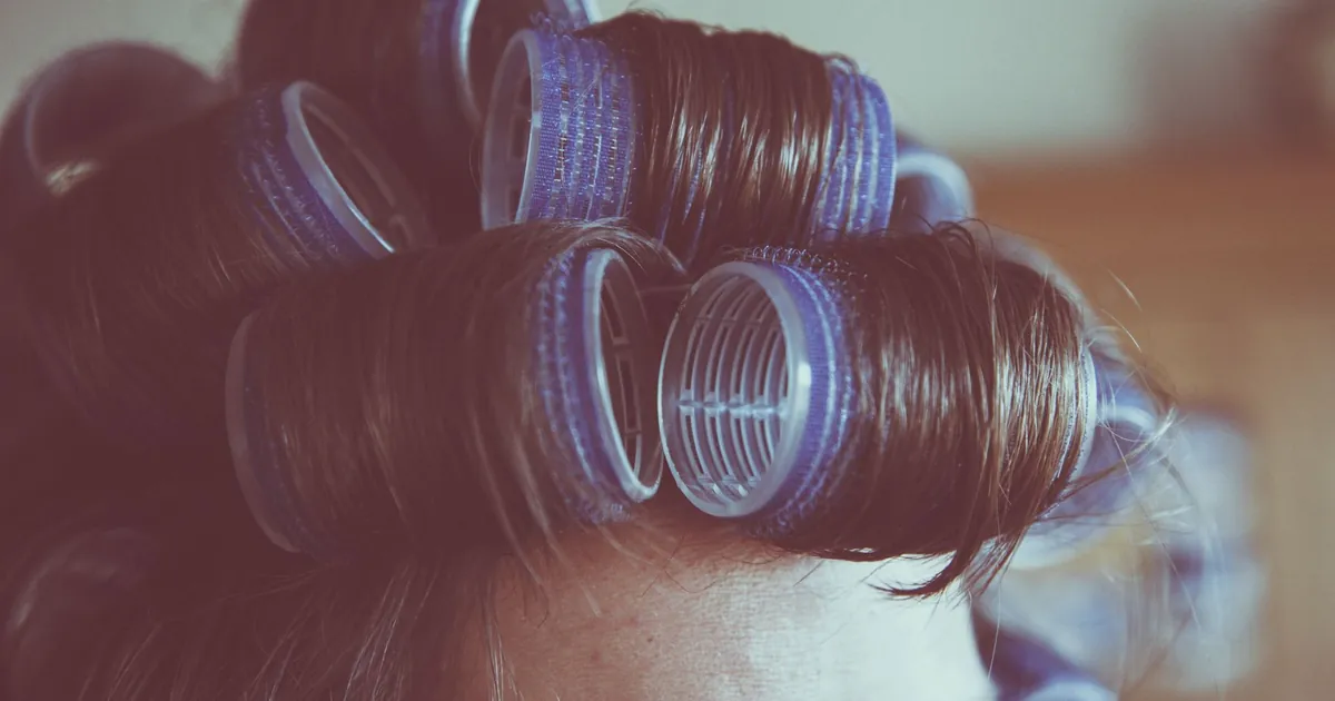 Gros plan style vintage des cheveux d'une femme en bigoudis, coiffure rétro.