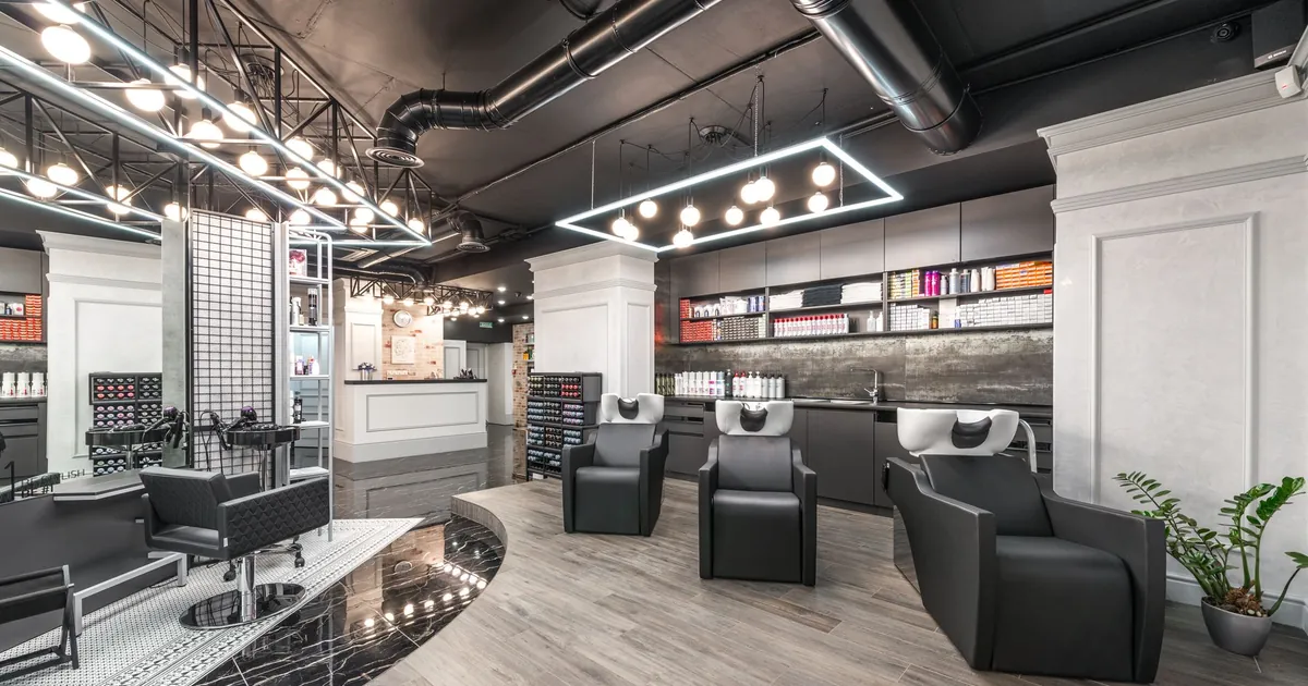 Fauteuils de lavage confortables avec bacs dans un salon de coiffure lumineux.